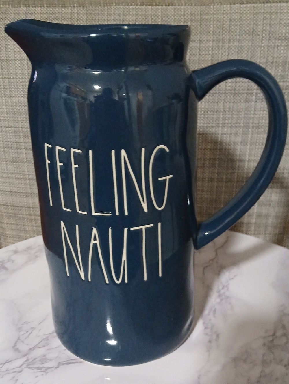 Rae Dunn navy ceramic pitcher with white lettering "FEELING NAUTI"